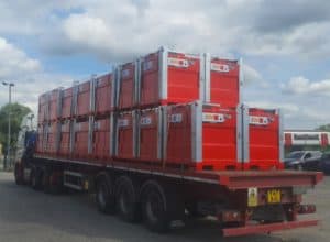 17 red steel tanks on back of a lorry.