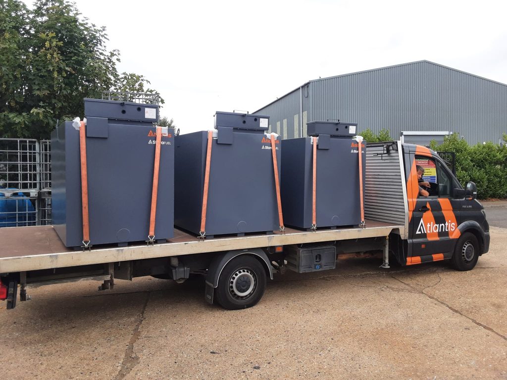 Three grey Imperium generator feed tanks secured on an Atlantis delivery truck.