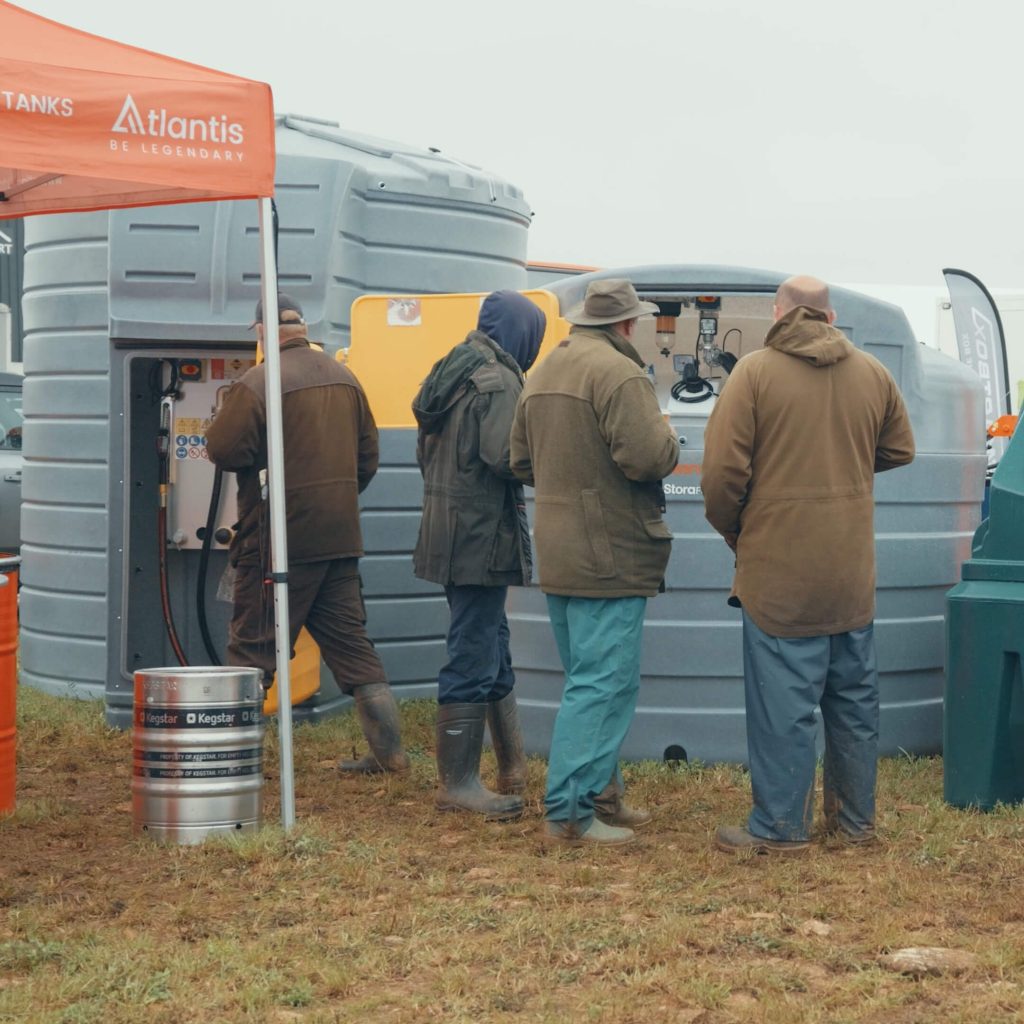Four visitors viewing fuel storage tanks beneath an Atlantis-branded canopy at Cereals 2026.